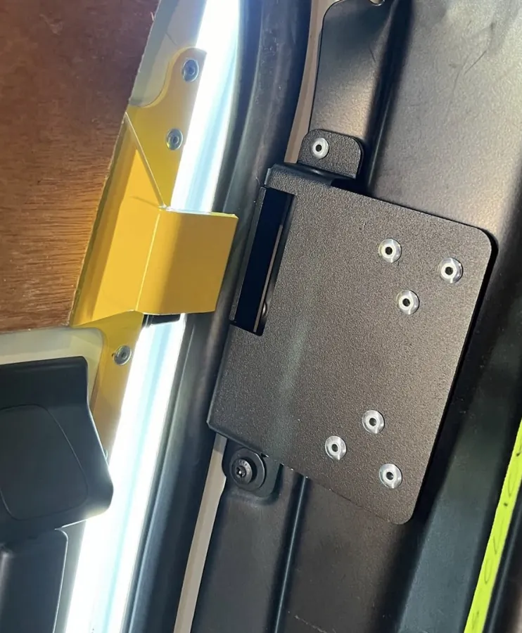 Yellow anti-peel bracket and black plate viewed from the opposite side