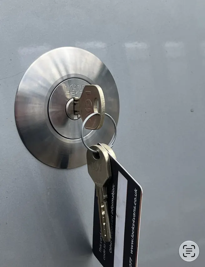 Close-up of round stainless-steel replacement security lock with key