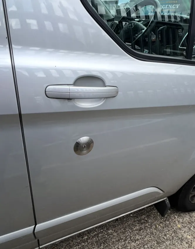 Van door with circular replacement security cylinder fitted below the handle
