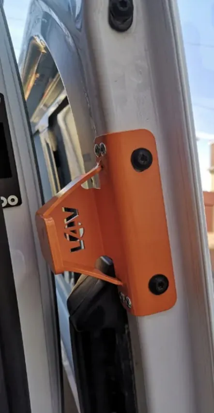 Orange anti-peel bracket on the frame of an open van sliding door