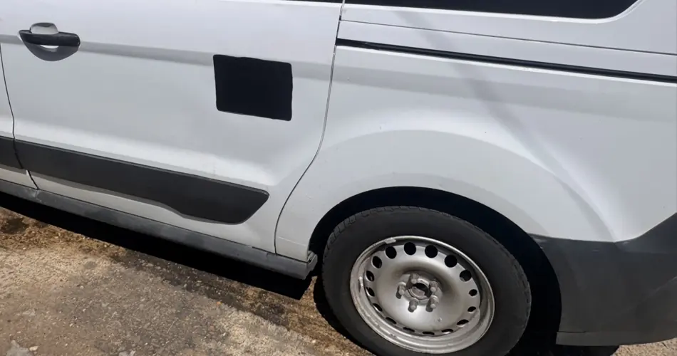 Side view of black security plate on white van sliding door