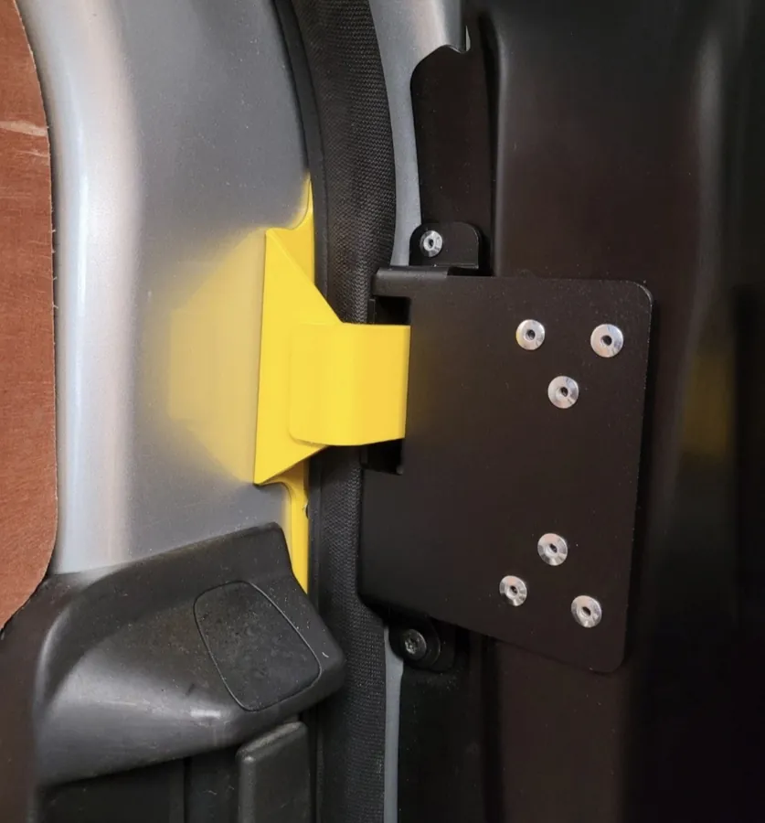 Yellow and black anti-peel bracket fitted to a van sliding door
