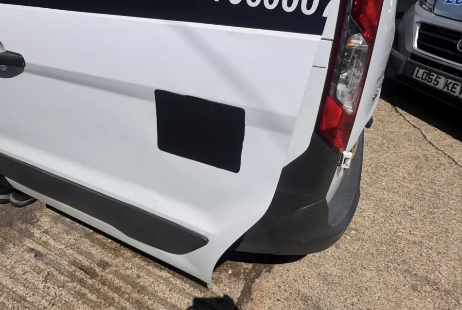 Black external cover plate fitted on white van rear door