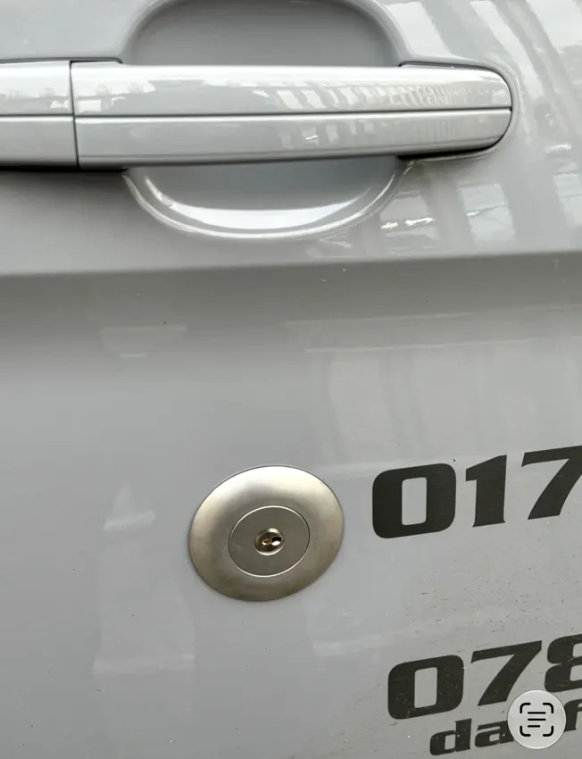 Close-up of round silver security lock cylinder fitted to van door