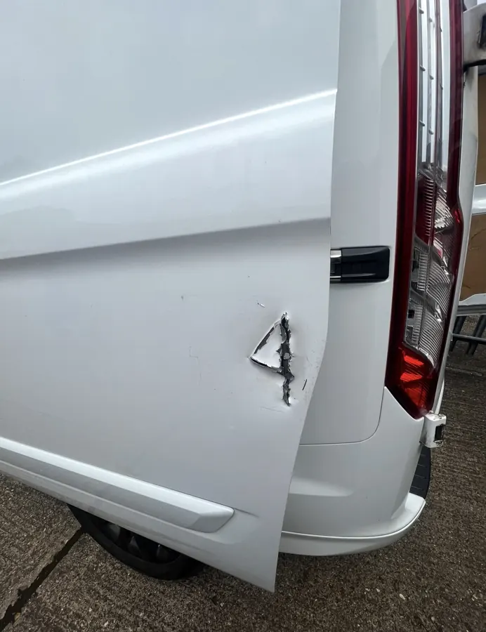 White van door showing damage before repair