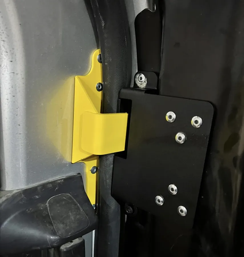 Close-up of yellow interlocking anti-peel bracket fitted to sliding van door